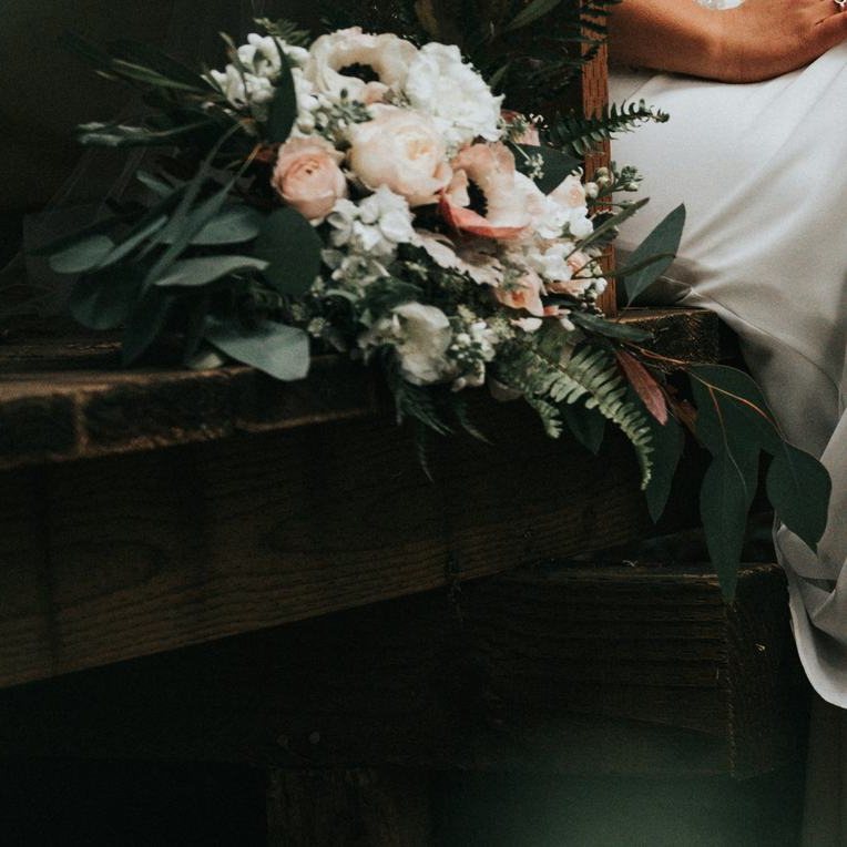 Le bouquet de la mariée posé sur un banc en bois