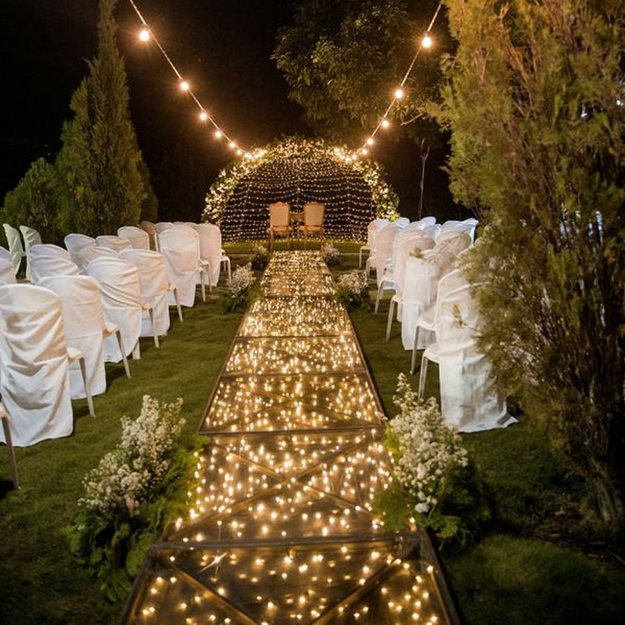 Une allée éclairée de guirlandes lumineuses, de nuit