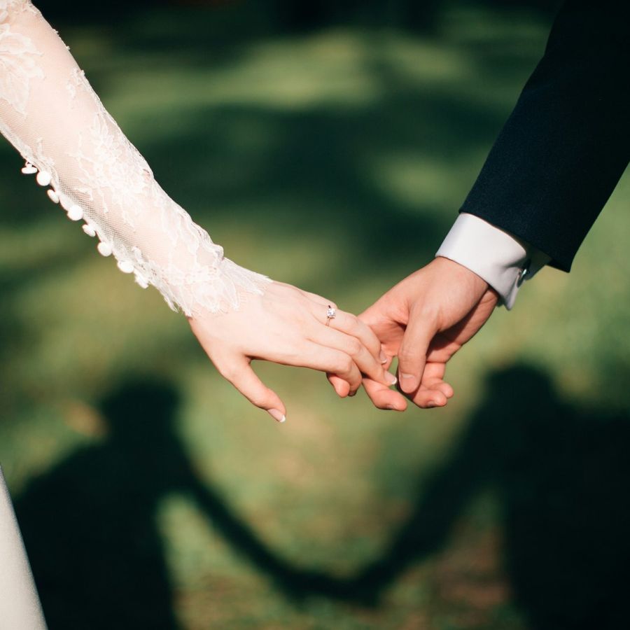 Mains des mariés, manche de dentelle et alliance